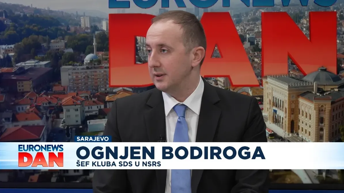Portret Ognjena Bodiroge, šefa kluba SDS u Narodnoj skupštini Republike Srpske (NSRS), kako sjedi u studiju Euronews Dan u Sarajevu. U pozadini se vidi gradski pejzaž Sarajeva i logotip Euronews Dan.