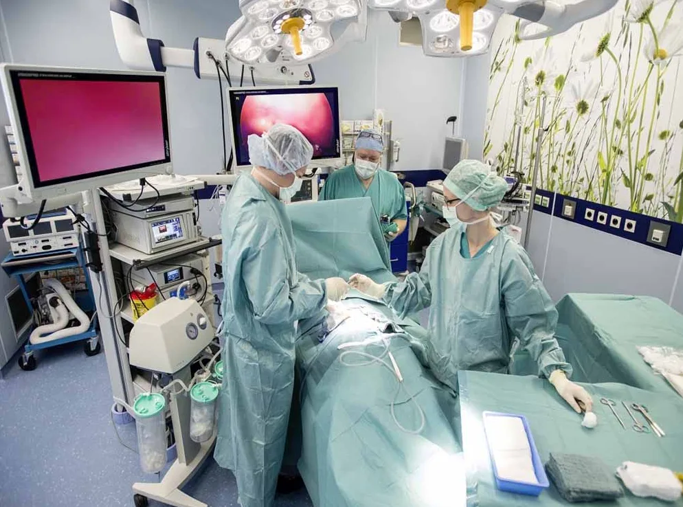 Tim hirurga i medicinskog osoblja u operacionoj sali vrši hiruršku intervenciju.