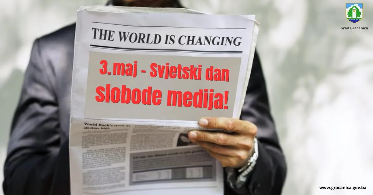 Osoba u tamnom odijelu drži novine sa natpisom "THE WORLD IS CHANGING" i istaknutim crvenim slovima "3. maj - Svjetski dan slobode medija!".
