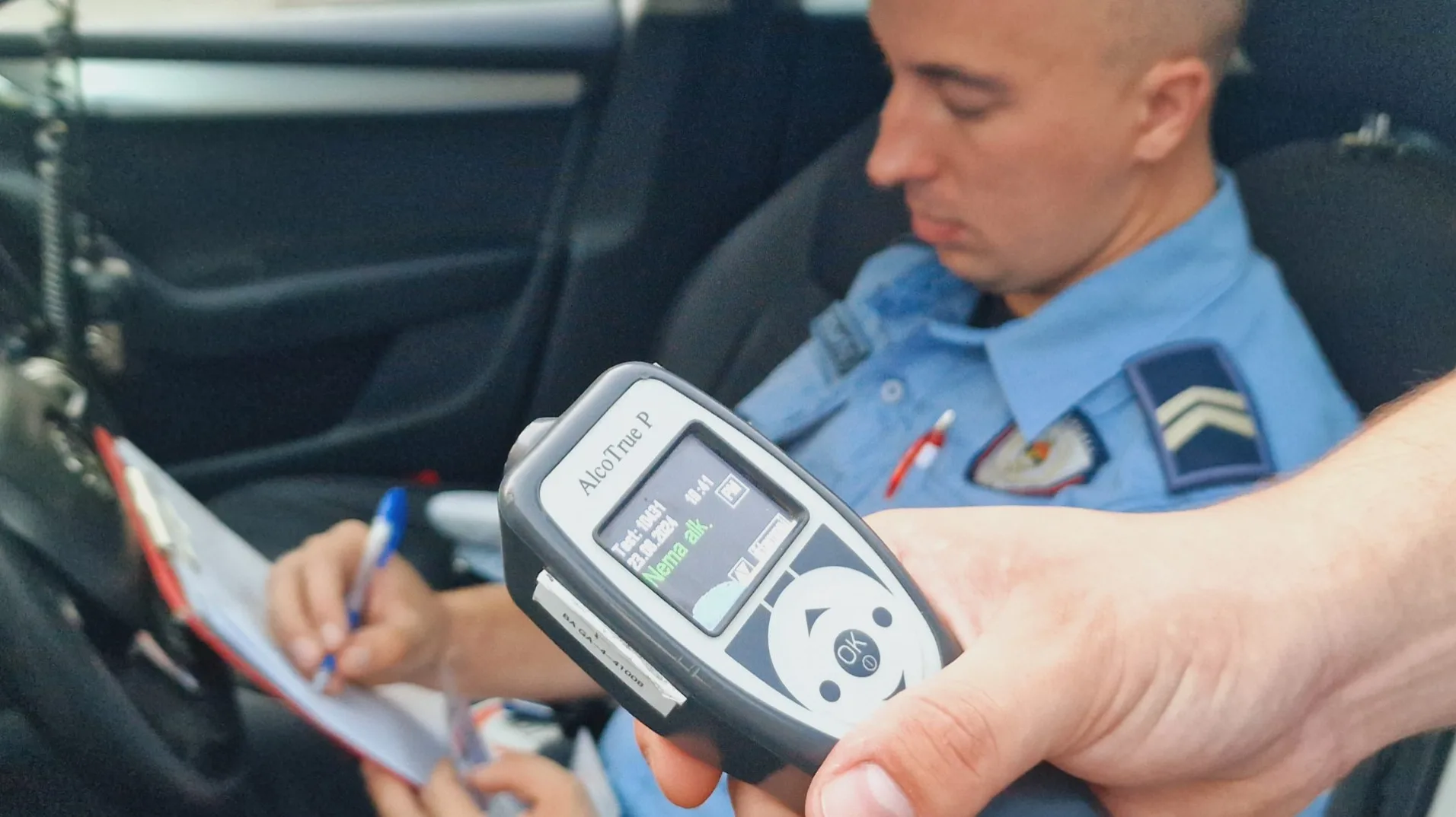 Policajac drži alkometar i piše u svesku