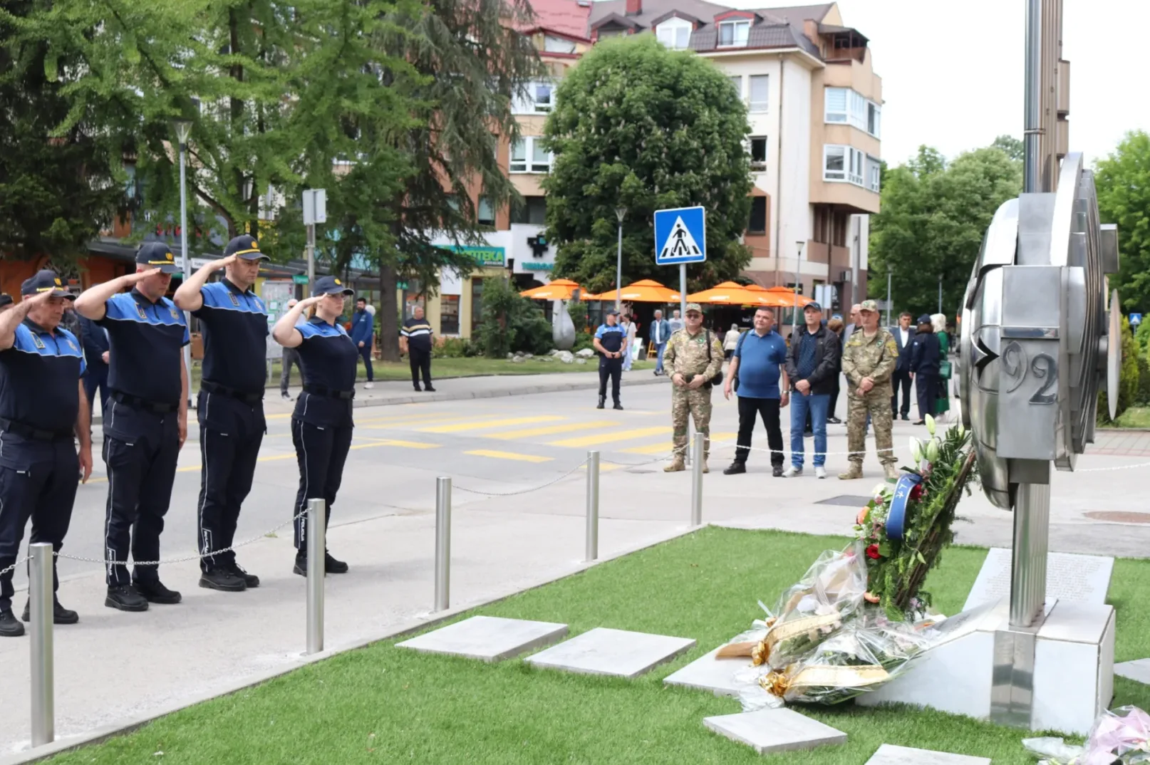 Policijski službenici odaju počast kod spomenika.