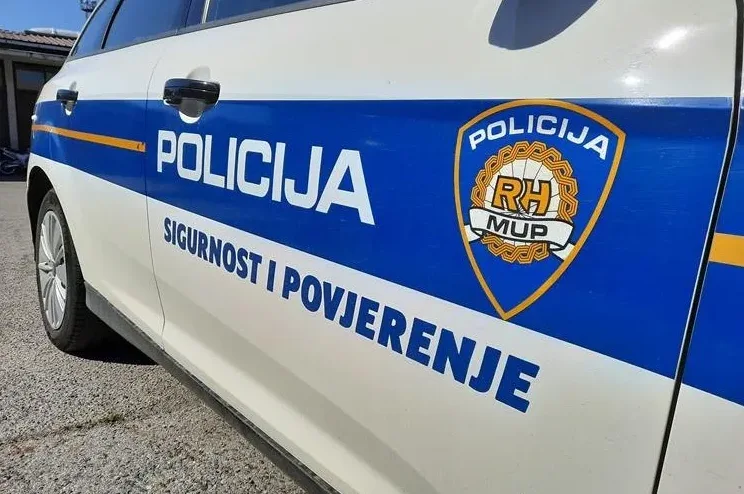 Hrvatsko policijsko vozilo sa ispisom "POLICIJA" i "SIGURNOST I POVJERENJE" te grbom RH MUP.
