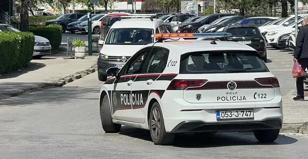 Policijsko vozilo marke Volkswagen Golf sa upaljenom rotacijom parkirano pored kolovoza.