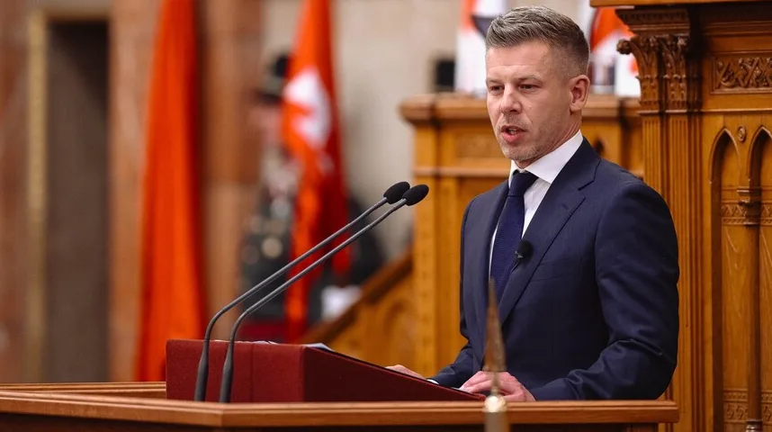 Političar u tamnom odijelu i plavoj kravati govori za govornicom sa dva mikrofona.