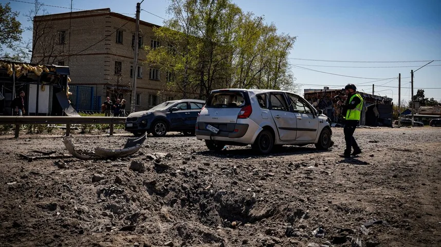 Uništen automobil i oštećena zgrada nakon granatiranja u Ukrajini.