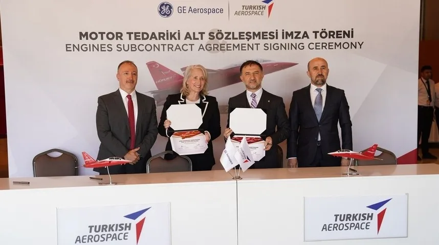 Četiri osobe stoje iza stola, držeći potpisane dokumente, sa modelima aviona ispred njih.