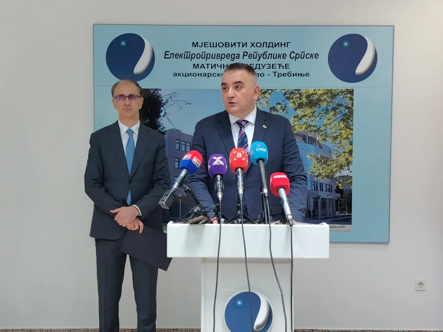 Dva muškarca u odijelima stoje ispred postolja s mikrofonima tokom press konferencije Elektroprivrede Republike Srpske u Trebinju.