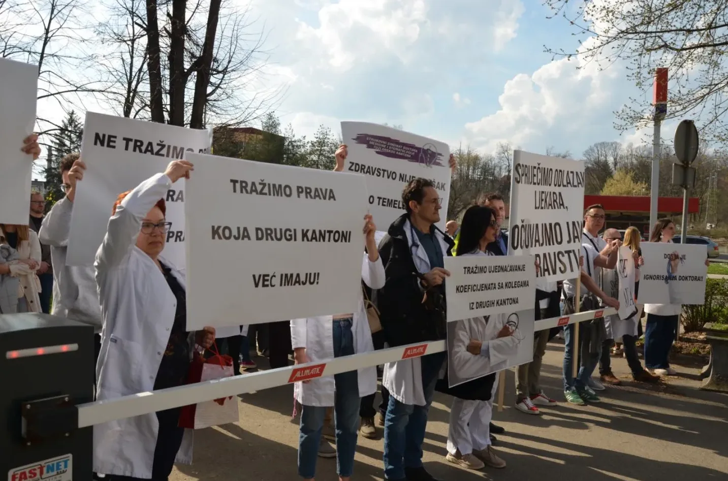 Grupa ljekara drži transparente na protestu, tražeći jednaka prava i bolje uslove rada.