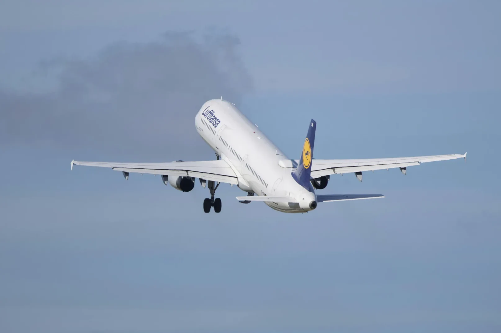 Bijeli putnički avion kompanije Lufthansa sa plavim repom uzlijeće na vedrom nebu.
