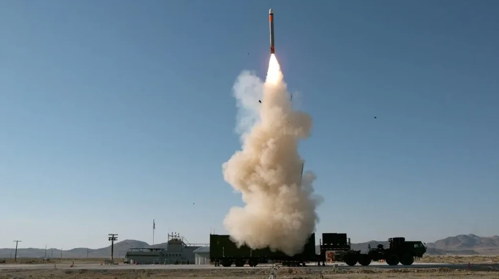 Raketa lansirana u nebo sa mnogo dima i plamena koji izlazi iz lansirne rampe.