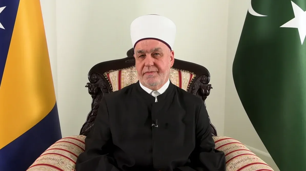 Reis-ul-ulema Husein ef. Kavazović sjedi u fotelji između zastava Bosne i Hercegovine i Pakistana.