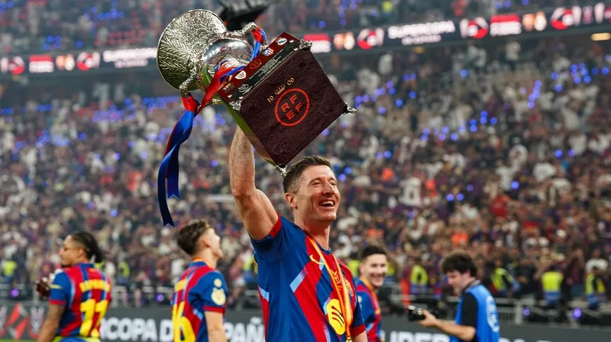 Robert Lewandowski, fudbaler Barcelone, podiže trofej Superkupa Španije iznad glave, slaveći pobjedu.