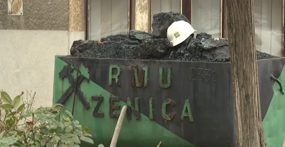 Kiper pun rude i uglja sa natpisom "RMU ZENICA" i rudarskim simbolima krstače i pijuka.