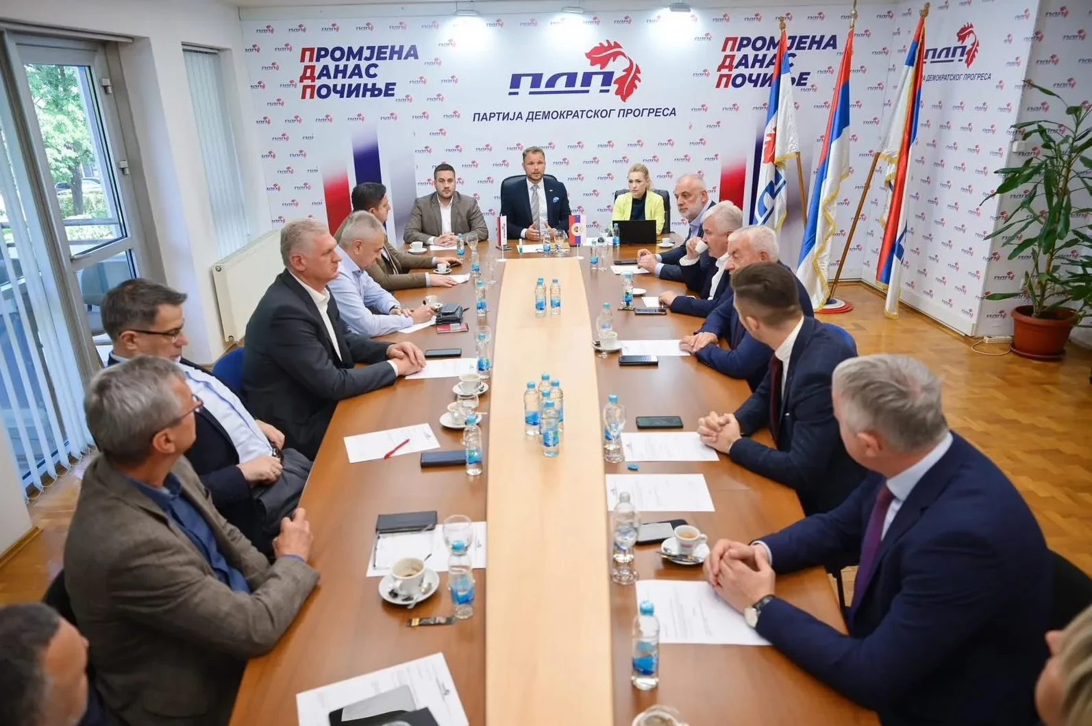 Članovi Partije demokratskog progresa sjede za dugačkim stolom na sastanku.