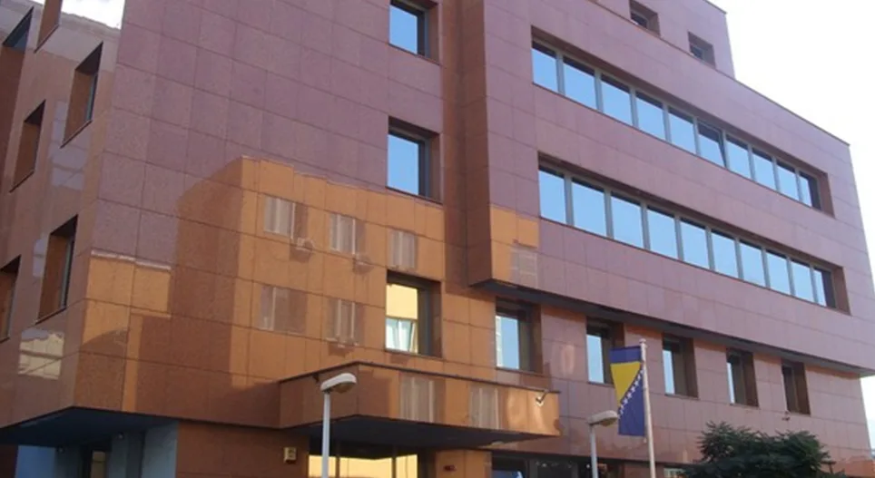 Moderna smeđa zgrada sa velikim prozorima i granitnim fasadnim oblogama.