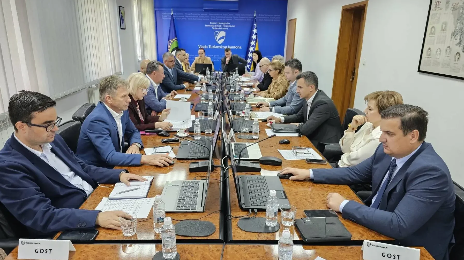 Učesnici sjednice Vlade Tuzlanskog kantona za dugačkim stolom, okruženi laptopima i dokumentima.