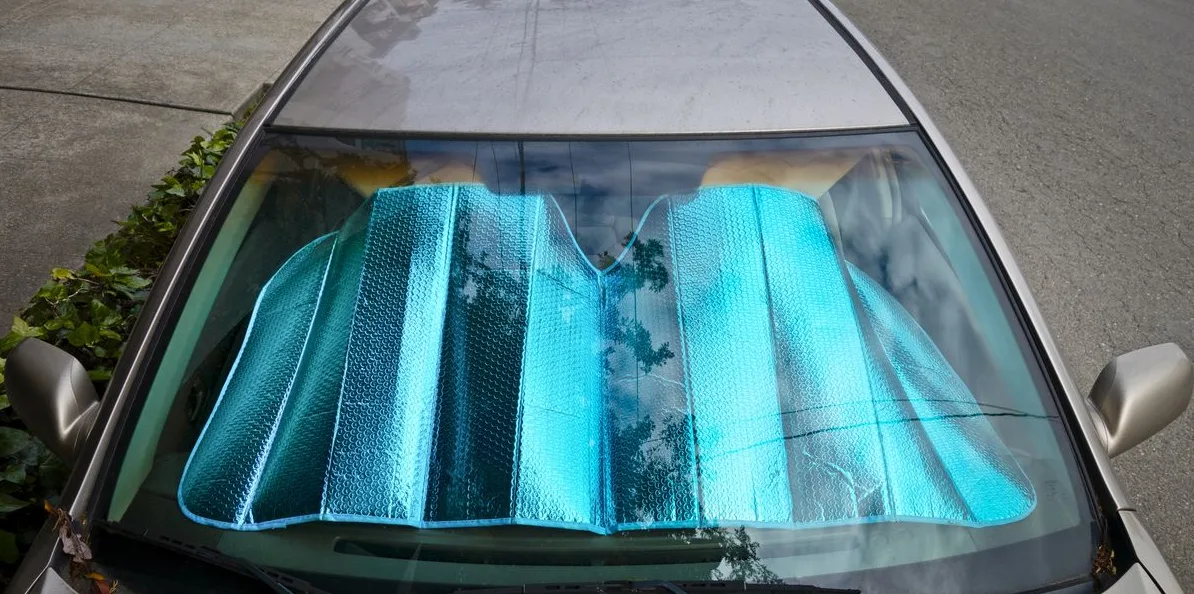 Plavo sjenilo za vjetrobransko staklo automobila postavljeno iznad kontrolne table.
