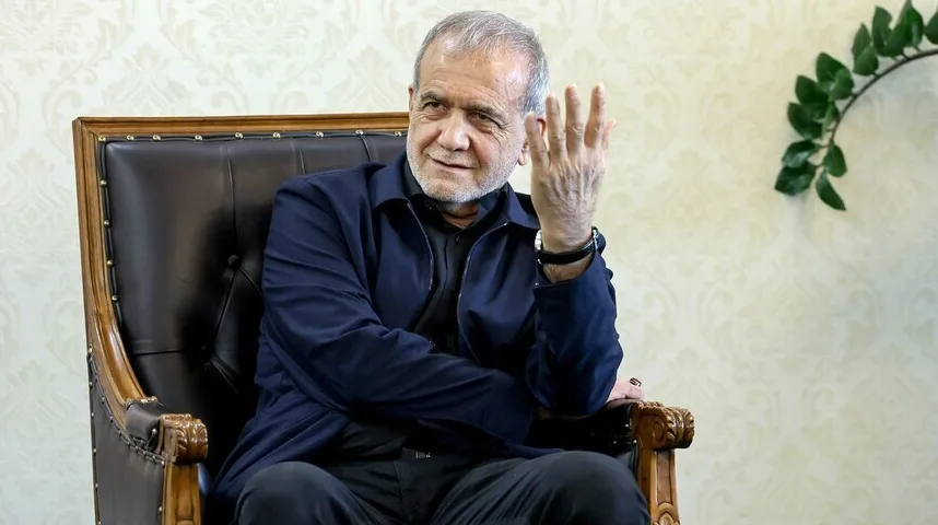 Portret starijeg muškarca sijede kose, obučenog u tamnu jaknu preko crne košulje, koji sjedi u kožnoj fotelji i gestikulira desnom rukom.