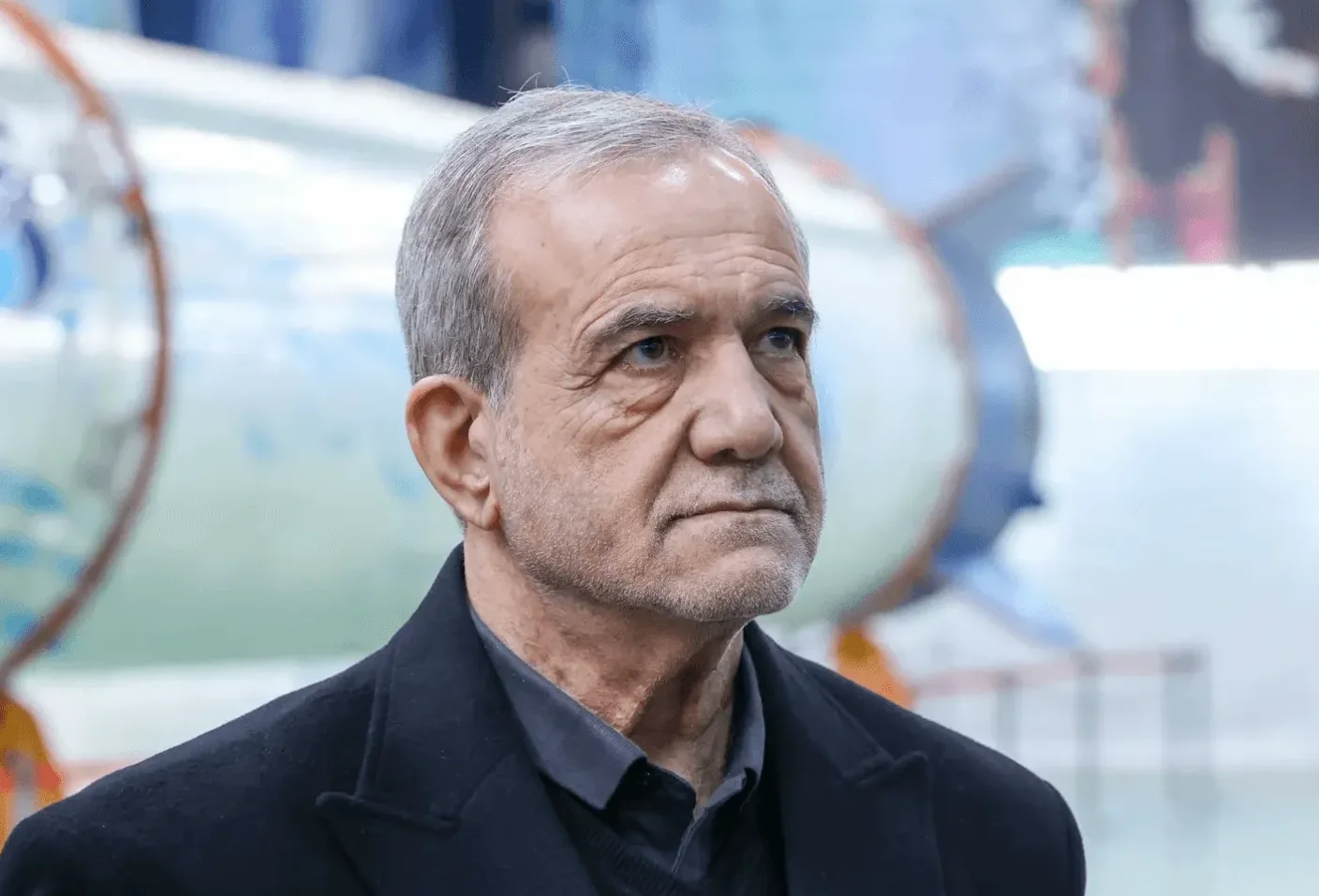Portret starijeg muškarca sijede kose, obučenog u crni kaput, sa ozbiljnim izrazom lica.