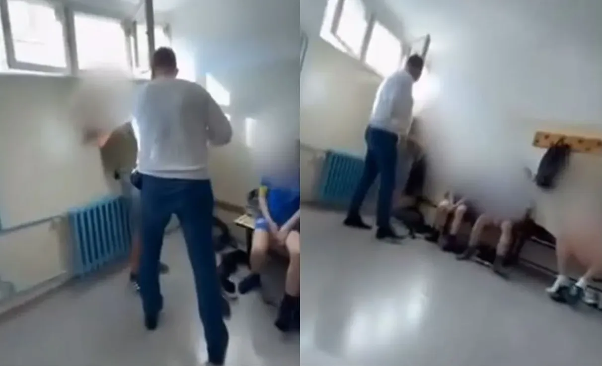 Snimak prikazuje učitelja koji stoji nasred učionice, dok su učenici raspoređeni uz zid.