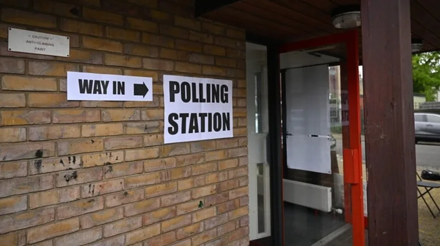 Natpis "WAY IN" s bijelim slovima na crnoj pozadini i strelicom koja pokazuje udesno, te natpis "POLLING STATION" sa istim slovima i pozadinom, obavještavaju birače o ulazu u biračko mjesto.