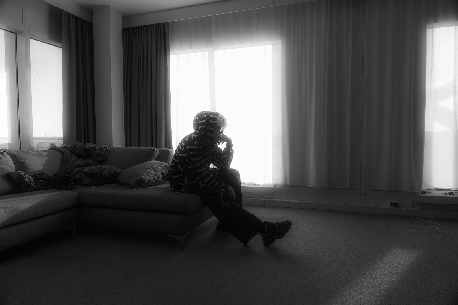 A person sits silhouetted in a bright room.