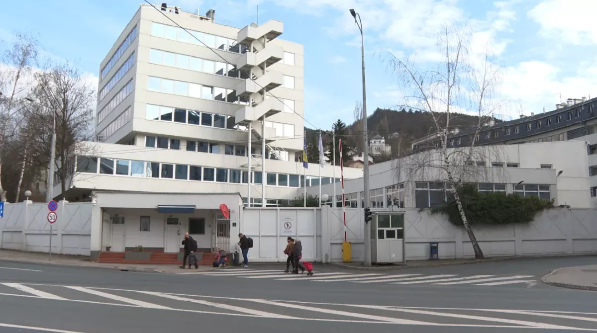 Moderna zgrada sa stepeništem na vanjskoj strani, zastavama Bosne i Hercegovine i EU, te obezbjeđenjem.
