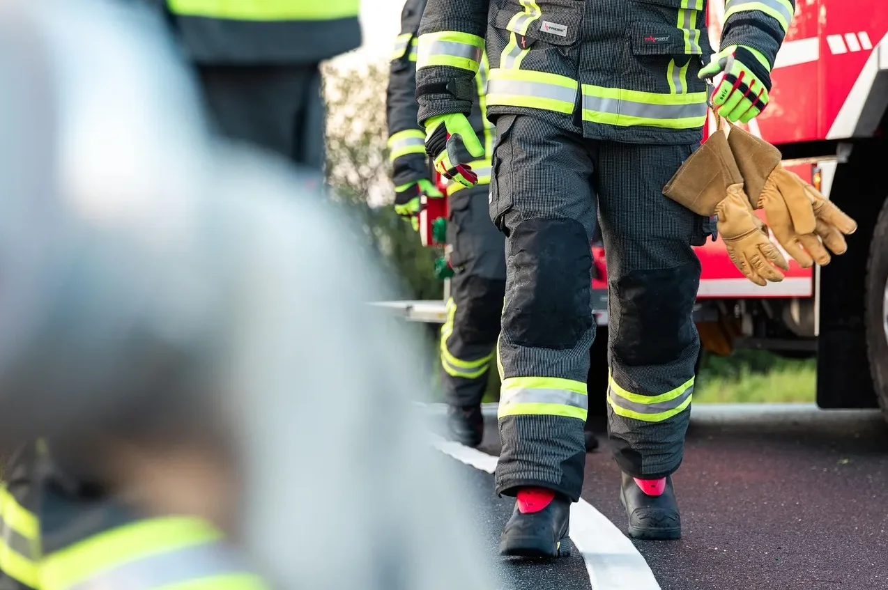 Detalj na nogama vatrogasaca u zaštitnim odijelima i rukavicama