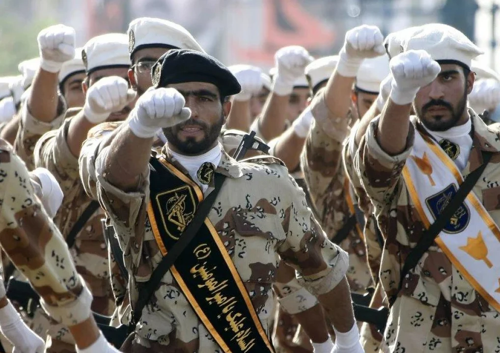 Vojnici u vojnim uniformama i beretkama podignutih pesnica na paradi.