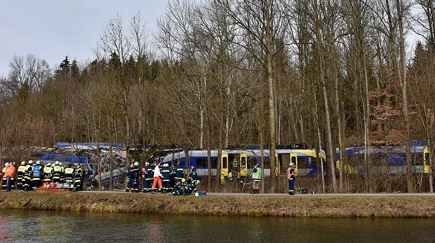 Vatrogasci u punoj opremi okupljeni oko isključenog voza pored šume i rijeke.