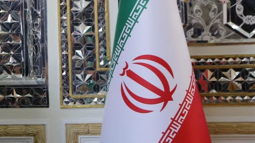 Detalj zastave Islamske Republike Iran istaknute u raskošno uređenoj prostoriji s ukrasnim ogledalima i zlatnim detaljima.