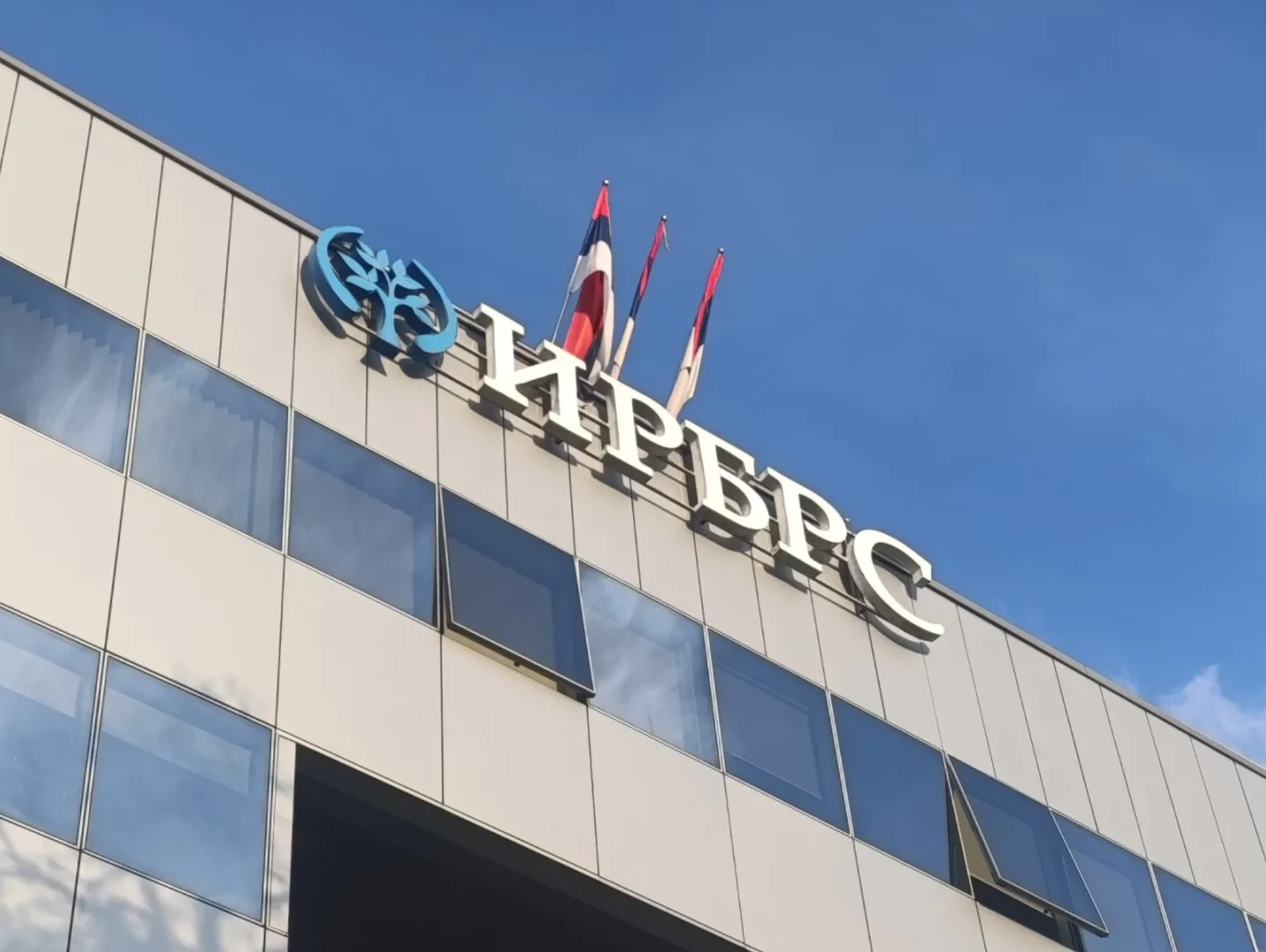 Zgrada sa bijelim slovima "НРБРС" i plavim logom stabla, uz zastave Republike Srpske na vrhu.