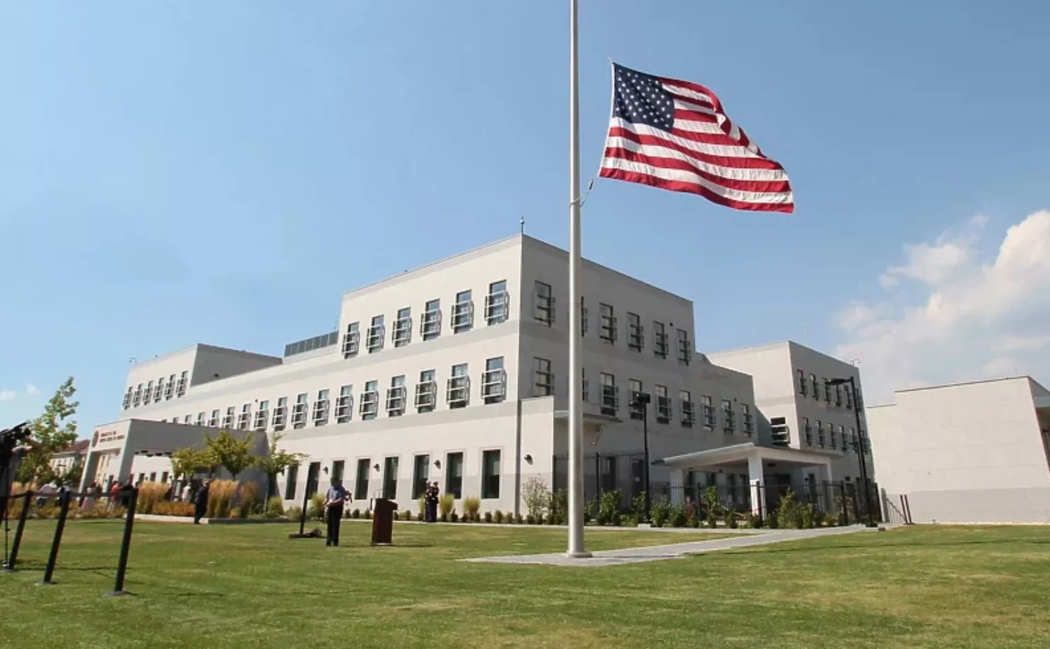 Američka zastava na jarbolu ispred moderne zgrade ambasade Sjedinjenih Američkih Država
