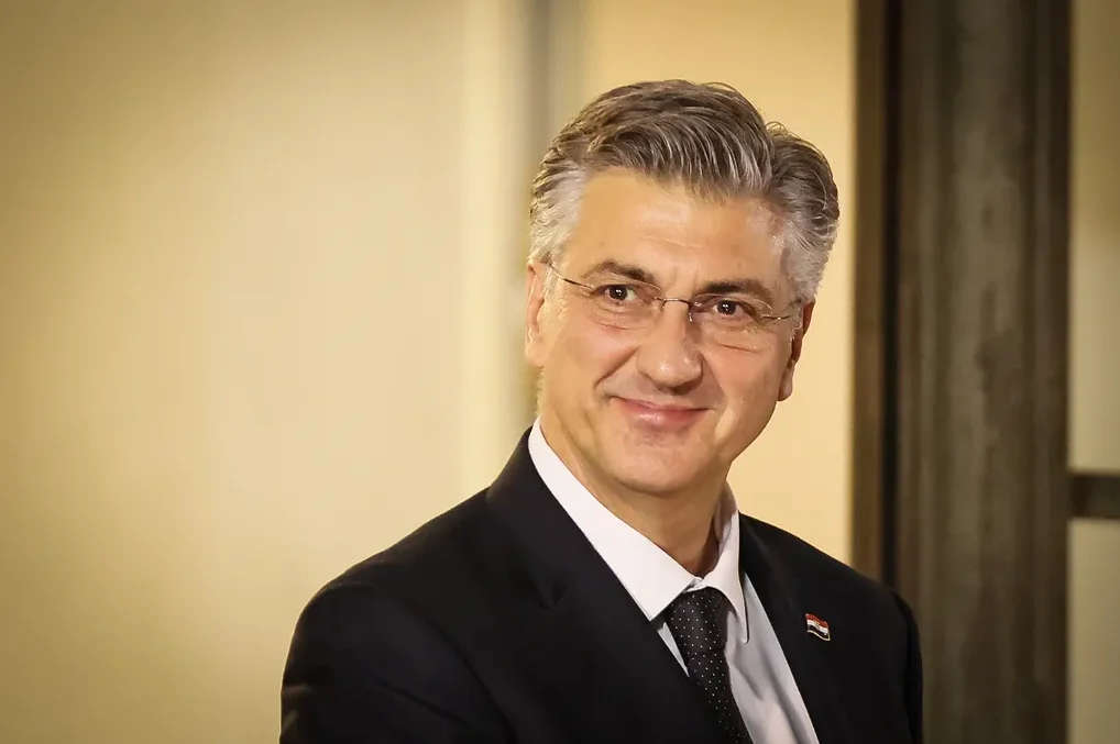 Portret Andreja Plenkovića, premijera Hrvatske, koji nosi odijelo i naočale.