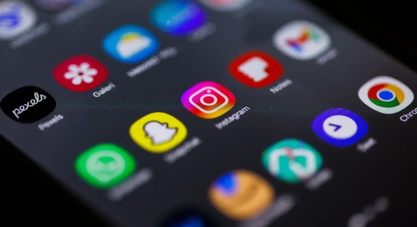 Zatvoren pogled na zaslon pametnog telefona koji prikazuje brojne ikone aplikacija, uključujući Instagram, Snapchat, Pexels i Google Chrome.