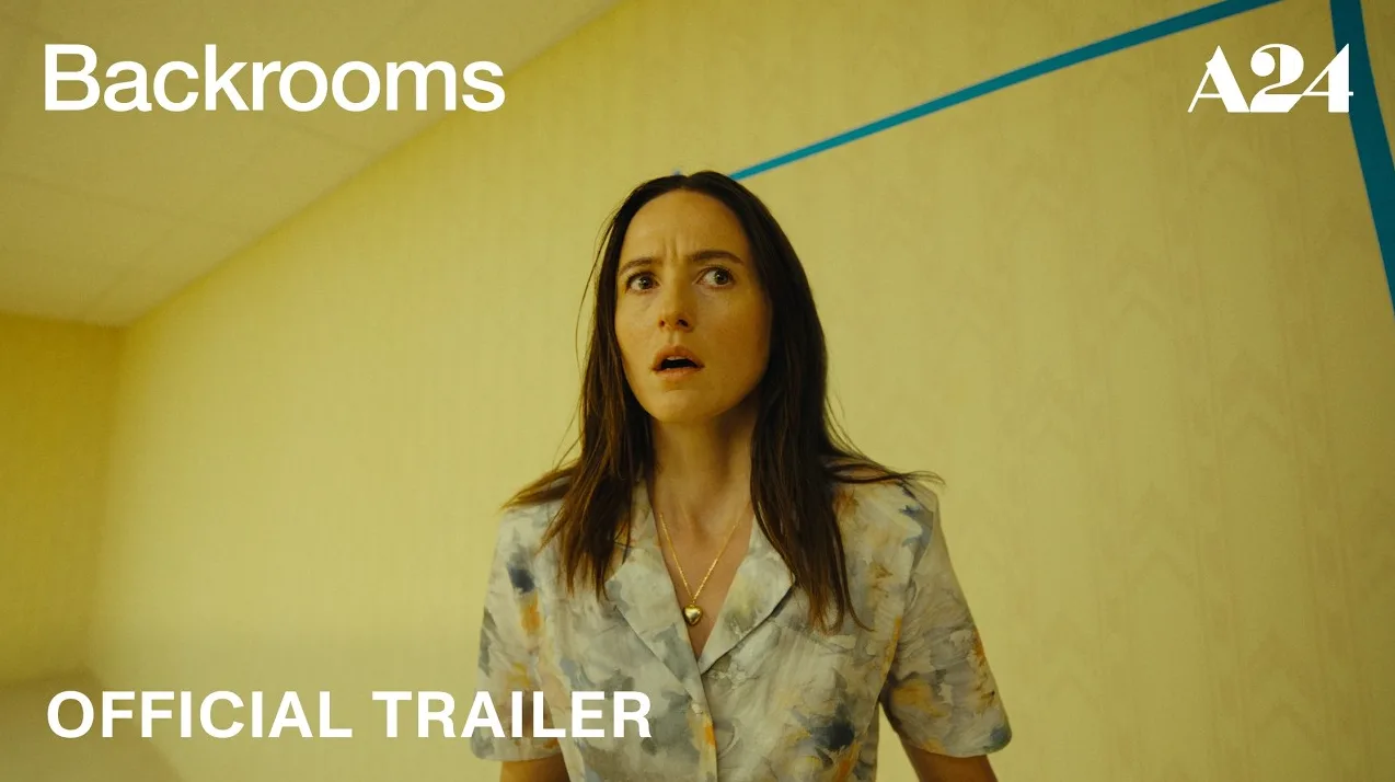 Žena sa iznenađenim izrazom lica u žutom ambijentu sa natpisom "Backrooms" i "OFFICIAL TRAILER"