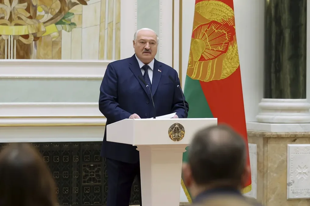 Predsjednik Bjelorusije Aleksandar Lukašenko govori za podijumom pored bjeloruske zastave.