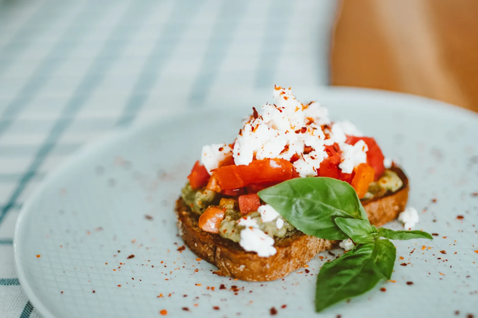 Bruschetta s avokadom, paradajzom, feta sirom i bosiljkom na tanjiru