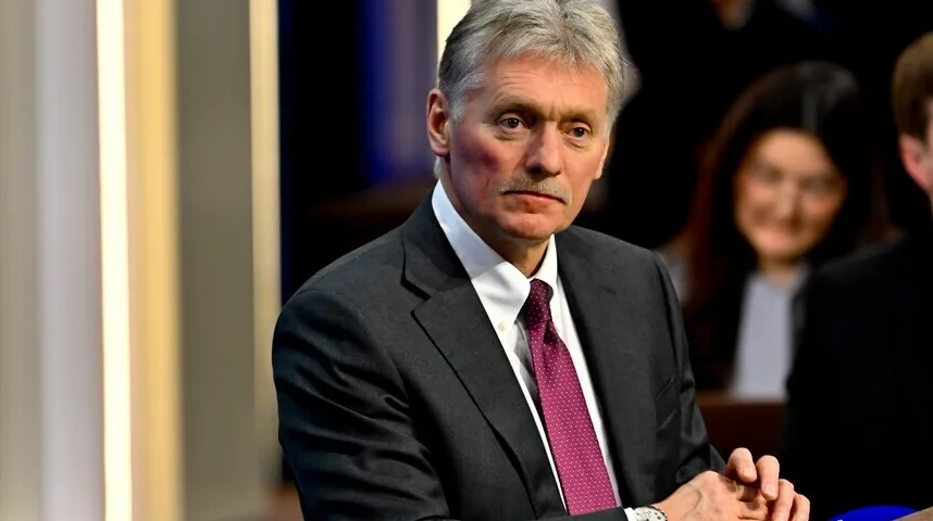 Dmitrij Peskov u tamnom odijelu sa bijelom košuljom i ljubičastom kravatom sa bijelim tačkicama.