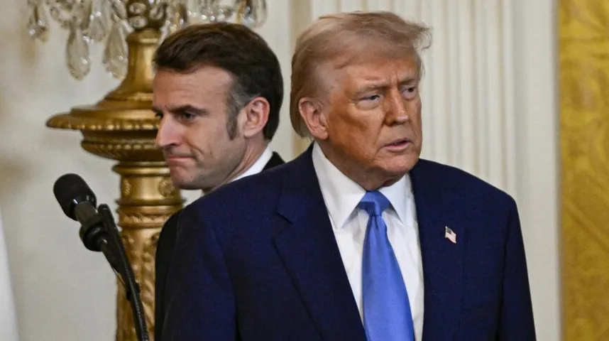 Donald Trump i Emmanuel Macron stoje jedan pored drugog u odijelima.