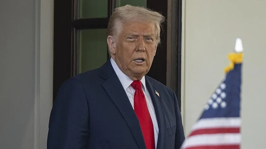 Donald Trump u odijelu pored zastave Sjedinjenih Američkih Država