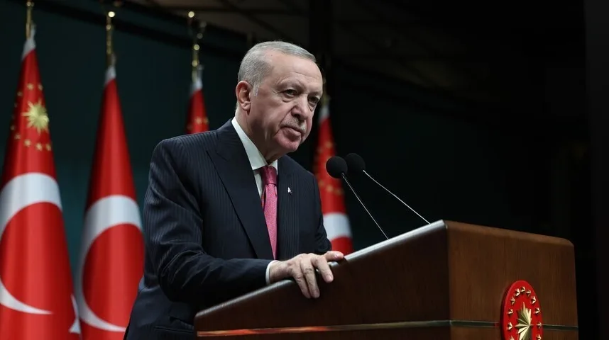 Recep Tayyip Erdoğan govori iza podijuma sa zastavama Turske u pozadini.