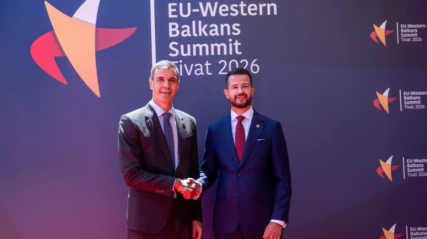 Dvojica muškaraca u svečanim odijelima rukuju se ispred banera sa natpisom "EU-Western Balkans Summit Tivat 2026".