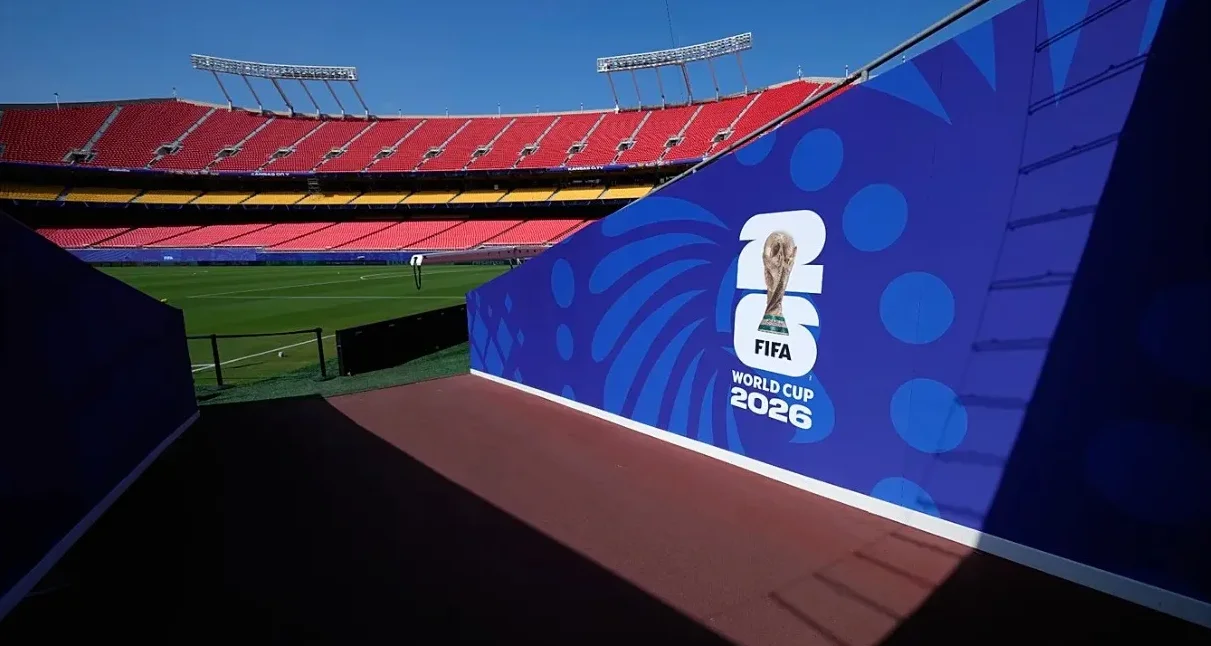 UEFA Liga Prvaka 2026. logo na plavom zidu pored fudbalskog terena