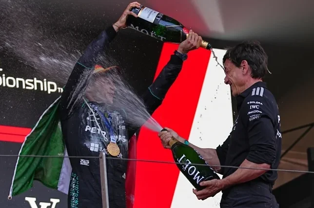 Vozač Formule 1 slavi pobjedu prskajući šampanjac.