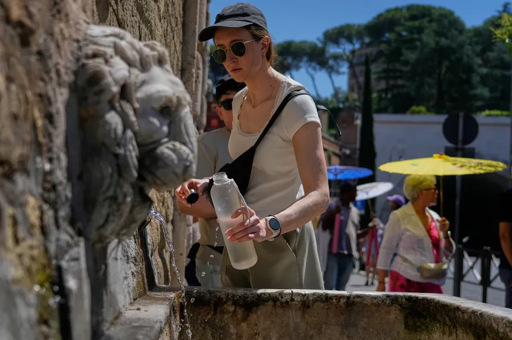 Žena sa flašom vode na fontani u Rimu