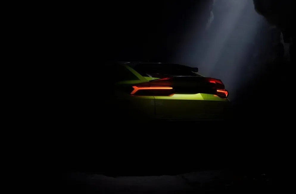 Zadnji dio futurističkog automobila limeta boje osvijetljen snopovima svjetlosti u mračnom ambijentu.