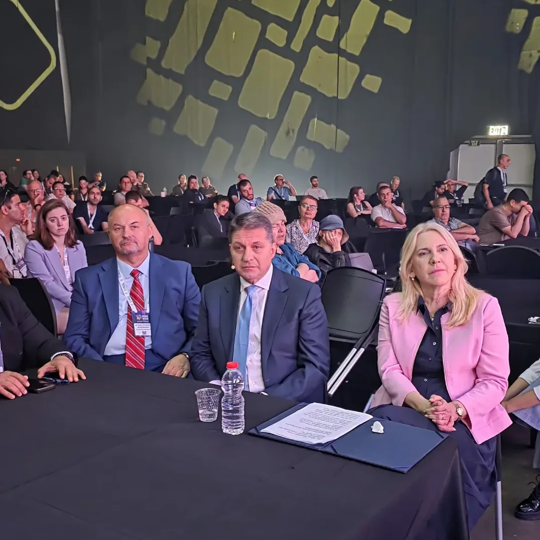Grupna fotografija ljudi koji sjede u dvorani tokom poslovne konferencije.