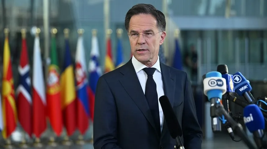 Holandski premijer Mark Rutte drži govor sa mnogo mikrofona ispred sebe, a u pozadini se vide zastave Evropske unije.