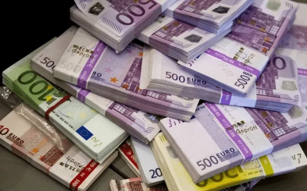 Slika prikazuje hrpu novčanica eura, uključujući apoene od 100€, 500€ i manje apoene.